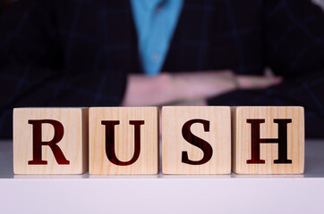 The word "RUSH" written on wood cube.