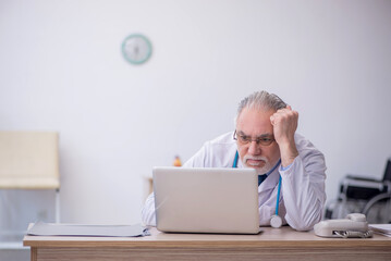 Old male doctor in telemedicine concept