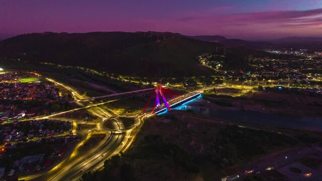 Aerial Hyperlapse Above Temuco City at Sunset Nighttime Chile, Roundabout, Cable Bridge above Cautin River, Hill Houses at Andean Valley Araucaria Region