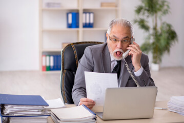 Old male employee working in the office