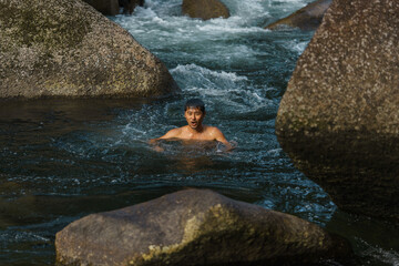 asian going for a swim in a river