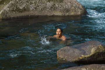 asian going for a swim in a cold river