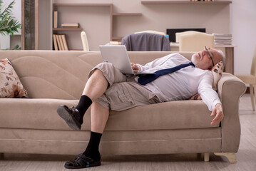 Fototapeta premium Old male employee working from home during pandemic