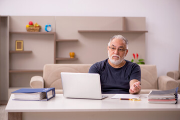 Old male employee working from home during pandemic