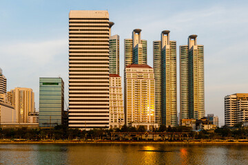 Fototapeta na wymiar Bangkok sunset reflection river sun. Panoramic view of light blue glass background of a high-rise building of a commercial future skyscraper. Architecture technology industry success business concept