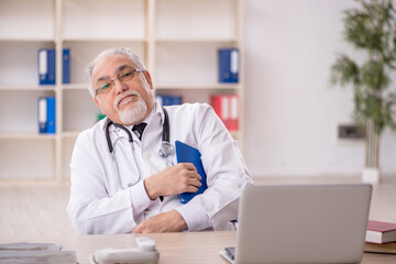 Old male doctor working in the clinic