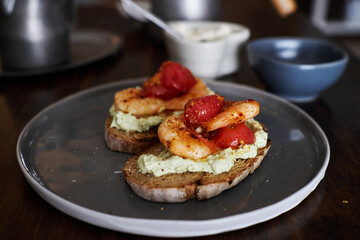 delicious open sandwiches: wholegrain toast topped with cheese, shrimp and tomatoes 