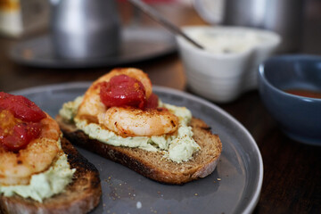 delicious open sandwiches: wholegrain toast topped with cheese, shrimp and tomatoes 