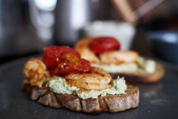 delicious open sandwiches: wholegrain toast topped with cheese, shrimp and tomatoes 