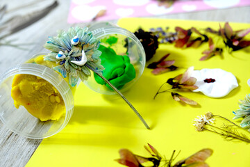 Autumn crafts. Child making crafts from natural dry plants, flowers, grass and leaves use paper and...