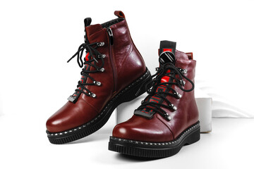 Women's boots on the platform on a white background. Burgundy shoes. Trend shoes. Stylish look. Fashion shoes still life. stylish photo in the studio