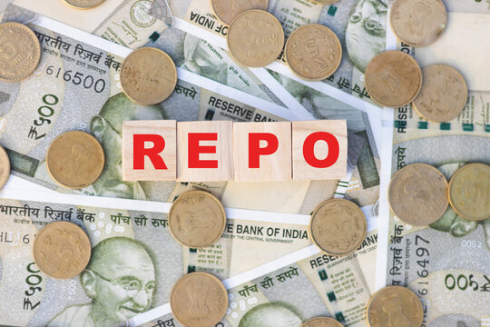 REPO repurchasing agreement text on wooden block cube, Indian bank note currency