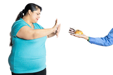 Overweight indian woman refuse and say no to junk food, Fat lady avoid burger and cake fast food....