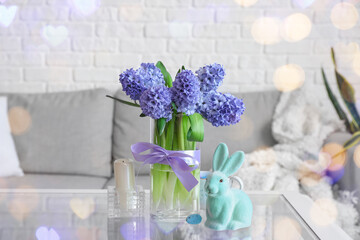 Easter bunny and vase with hyacinth flowers on table in living room