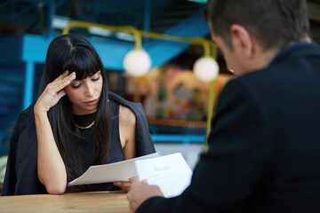 woman applicant feeling nervous and headache when hr recruitment officer holding resume and asking...