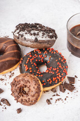 Delicious chocolate donuts on white table