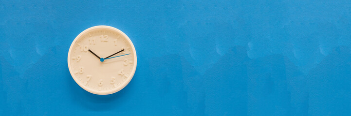 White big analogue plain wall clock on trendy pastel blue background. copy space, time management...