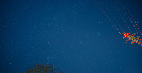 オリオン座やスバルなどのたくさんの冬の星と夜空と赤い鉄塔