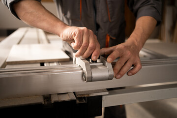 Man working on automatic woodworking machine in furniture factory.