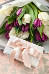 Gift box and bouquet of beautiful tulip flowers on grunge background. Hello spring