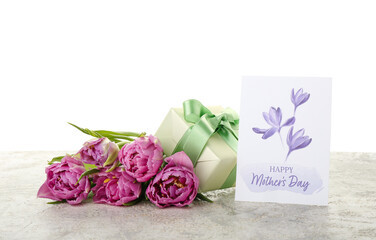 Greeting card with text HAPPY MOTHER'S DAY, tulips and gift on table against white background