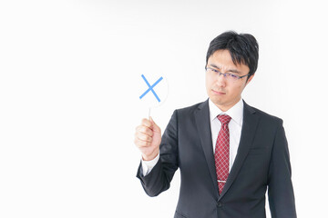 バツ印を示すビジネスマン