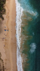 Fototapeta na wymiar Top view of beautiful beach. Aerial drone shot of turquoise sea water at the beach - space for text. Hawaiian seaside beach with turquoise water and big waves aerial view.