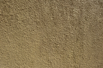 Textured background of a rough yellow wall