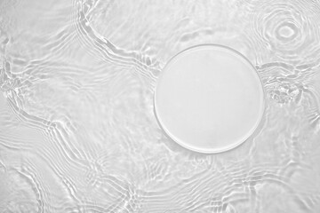 Empty clear white circle podium on transparent calm water texture with splashes and waves in...