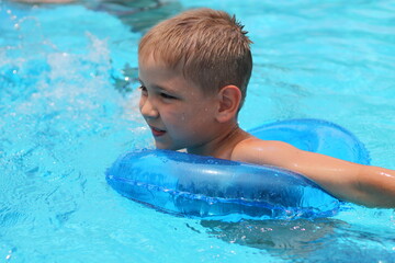 Cute happy little boy swimming and snorking in the swimming pool
