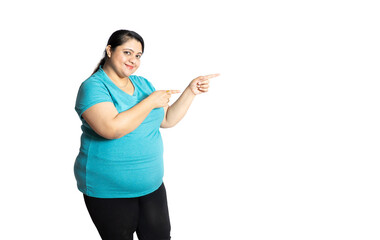 Happy Overweight plus size indian woman pointing at blank space to put advertisement standing...