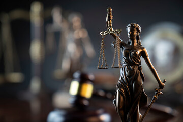 Law and justice concept. War crimes. Gavel and Themis sculpture in lawyers office. Gray bokeh background. - obrazy, fototapety, plakaty