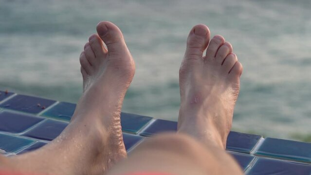 Male Feet By The Side Of The Pool with Ocean Background - Holiday Vacation Relax Theme