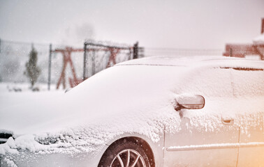 A snow covered car in winter storm