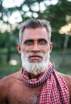 Portrait Of A South Asian Muslim Elderly Man Having White Long Beard , Asian Senior Citizen In Natural Environment, Experienced Farmer Looking At Camera 