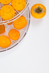 close-up, on round grills, fresh and dried persimmon fruit is cut, there is a place for an inscription