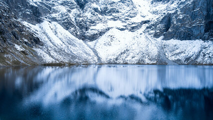 Czarny Staw pod Rysamy or Black Pond lake near the Morskie Oko Snowy Mountain Hut in Polish Tatry mountains, drone view, Zakopane, Poland. green hills and mountains in dark clouds and reflection  © anna.stasiia