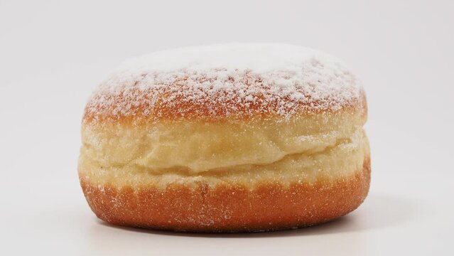 Freshly baked and powdered German donuts. Berlin donut or krapfen isolated on white background.