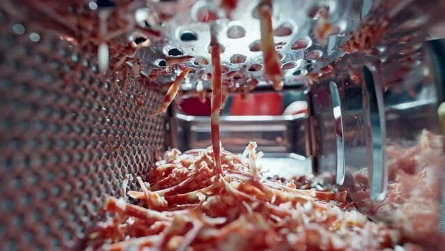 Slow motion close-up of chef grating red cheese in kitchen. Preparation of ingredients for pasta and pizza in a restaurant. High quality 4k footage