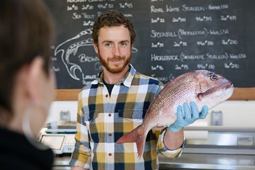 Shop assistant holding fish