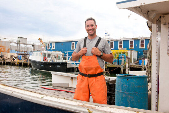 Portrait of proud lobsterman standing on his docked boat