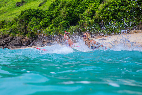 Surfer girls in ocean water.