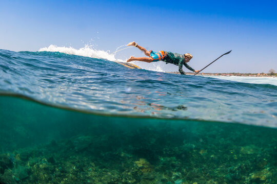 Sup surfing in tropical water.