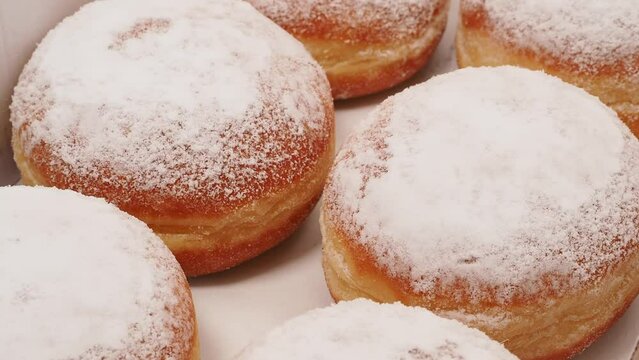 Freshly baked and powdered German donuts. Berlin donut or krapfen isolated on white background.