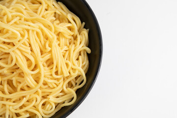 egg noodle in a black bowl isolated on white background