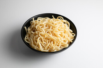 egg noodle in a black bowl isolated on white background