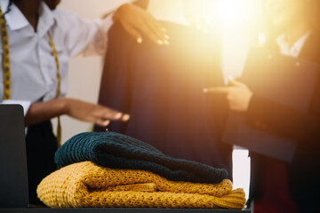 Diverse female fashion designers at work with tailor centimeters on necks and holds tablet and smartphone. independent creative design business. in studio