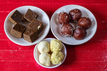 Khoya Kheer Kadam or Ras Kadam and Kala Jamun Indian Sweets in a White Plate Isolate on Wooden Background