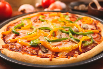 Homemade Italian pizza, mixed vegetables, cheese and bacon, fresh out of the oven. Placed on a dark wooden floor. Top view. Fast food concept.