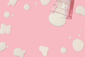 Creative layout with glass of spilled milk with spills on pastel pink background. background. 80s...